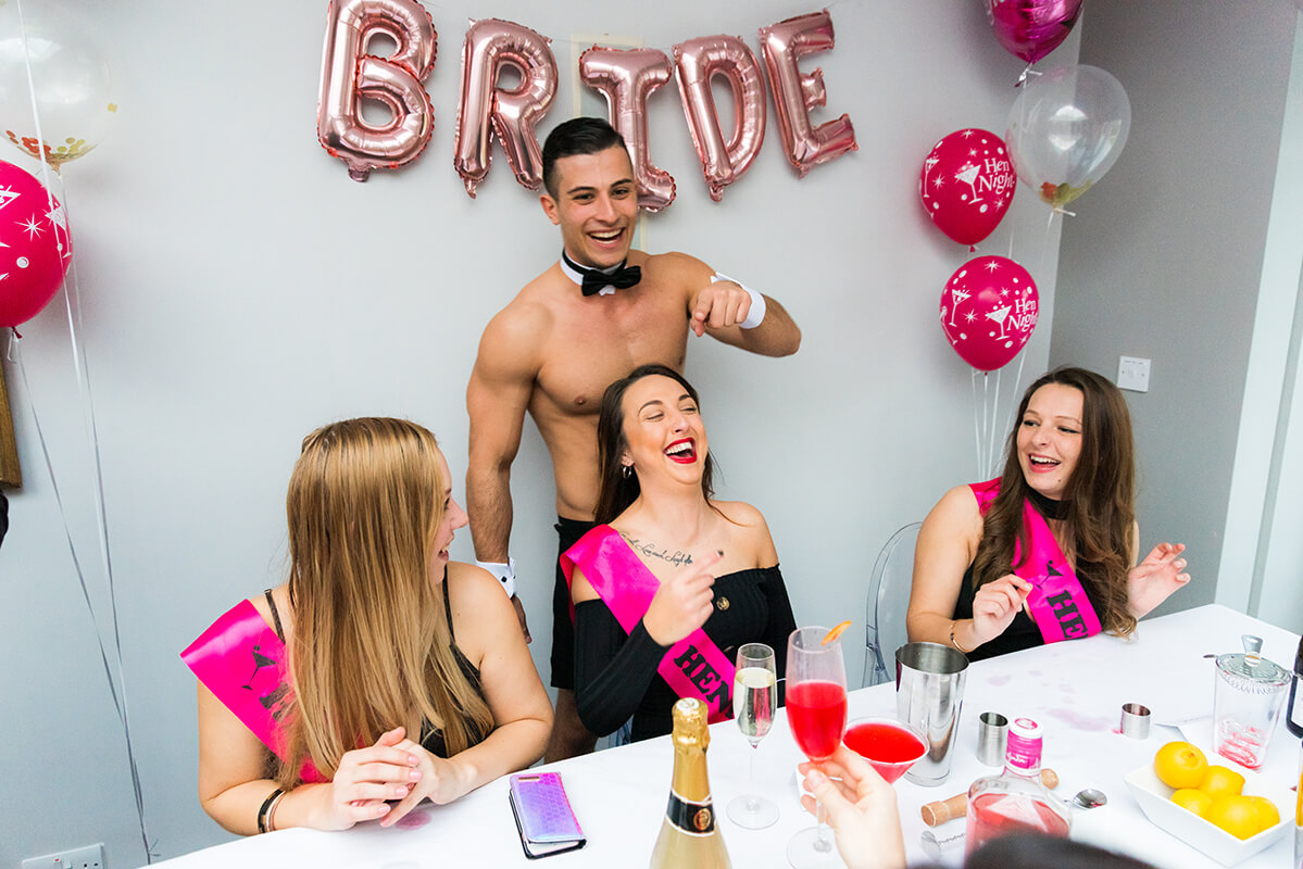 Girls laughing with butler at hen party